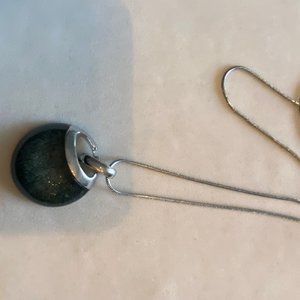 - Grey stone encased in silver pendant;  26" chain